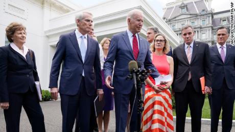 President Joe Biden, with a bipartisan group of senators, speaks outside the White House.