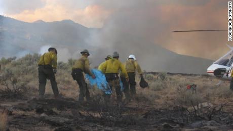 The Eldorado Hotshots medevac one of their own as Hump walks behind them during the New York Peak Fire in Nevada in 2006.