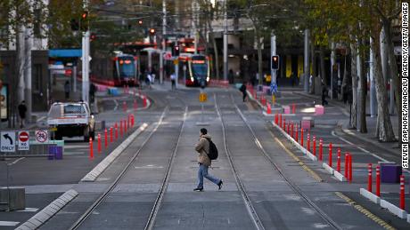 A man crosses a very quiet George Street in the center of Sydney, Australia, on the first day of lockdown on Saturday.