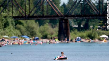 People gather at the Sandy River Delta in Oregon to cool off Friday. 