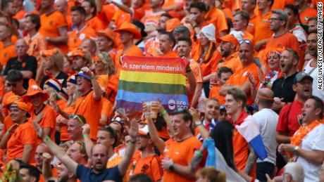 A fan of Netherlands is seen holding a rainbow flag.