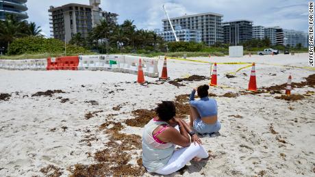 Beachgoers look at the site of the Champlain Towers South condo building collapse in Surfside, Florida. 