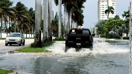 Cars maneuver through high-tide flooding in Fort Lauderdale, Florida.