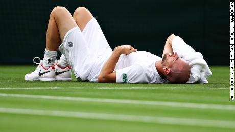 Adrian Mannarino of France reacts as he goes down with an injury in his first-round match against Roger Federer.