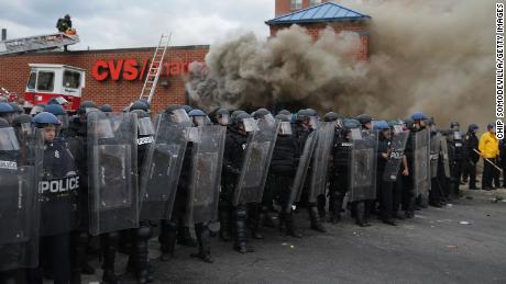 Baltimore Police form a perimeter around a CVS pharmacy that was looted and burned during protests after the funeral of Freddie Gray on April 27, 2015, in Baltimore. 