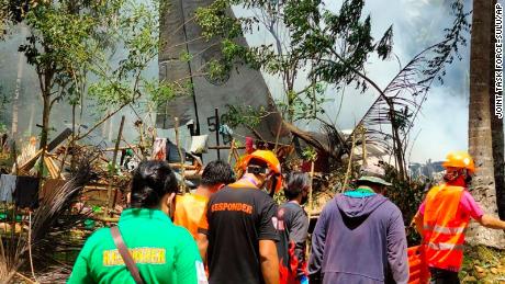 Rescuers search for bodies at the site where the plane crashed.