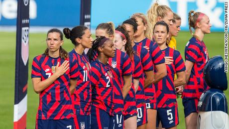Some members of the US women&#39;s national soccer team turn to face the American flag during the national anthem on July 5, 2021, while other members of the team face forward. (Mingo Nesmith/Icon SMI via ZUMA Press)