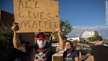 A man holds an &quot;All Lives Matter&quot; sign at a pro-Trump demonstration on August 1, 2020, in Yucaipa, California. 