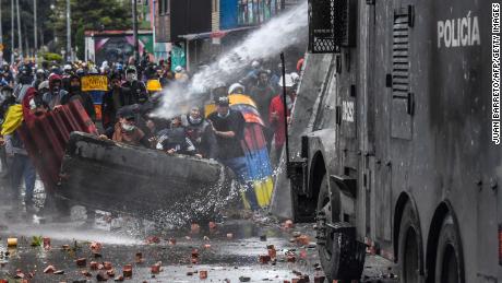 Police officers spray a water cannon at demonstrators during a protest in Bogota, Colombia, 6 월 9,