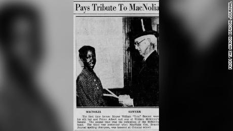 A newspaper clipping shows MacNolia Cox greeting former Akron Mayor William Sawyer while being honored at her school.