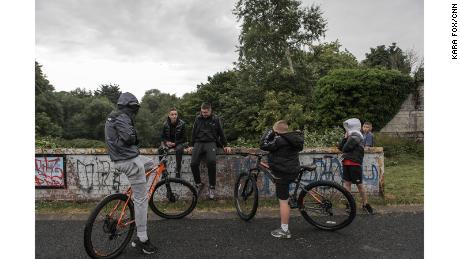 Youths gather near a &quot;peace wall&quot; in north Belfast&#39;s Alexandra Park. The peace wall, also referred to as a &quot;separation barrier,&quot; is one of dozens of structures erected to separate predominantly republican and nationalist neighborhoods. 
