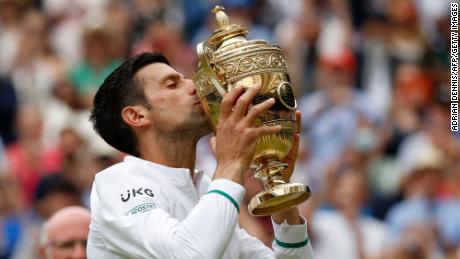 Novak Djokovic kisses the winner's trophy after defeating Matteo Berrettini of Italy in their men's singles final at the 2021 Wimbledon Championships.
