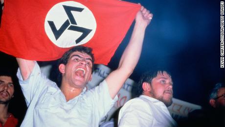 White South African man holds up a flag for the Afrikaner Resistance Movement (AWB), one of many groups that once threatened to push the nation into a civil war.
