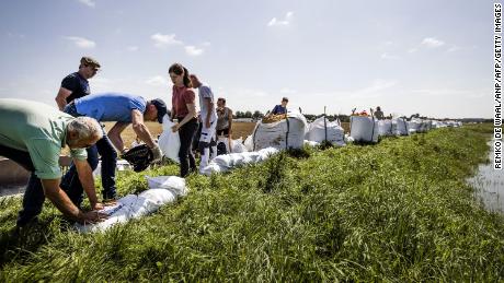 People build flood defenses using sandbags following heavy rains and floods in the Limburg province of the Netherlands.