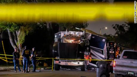 Os investigadores do ATF são vistos ao lado dos destroços de um veículo blindado do LAPD após a explosão de fogos de artifício.