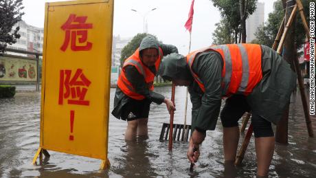 Workers drain water from a waterlogged area in Lanzhou, Henan, Cina, a luglio 20. 