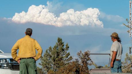 O especialista em Educação e Mitigação de Incêndios Ryan Berlin (L) e Bob Dillon assistem à nuvem de fumaça do Bootleg Fire da casa de Dillon em Beatty, Oregon, 16 de julho de 2021.