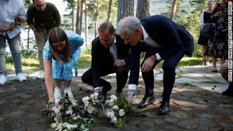 Leader of the youth organization of the Labour Party (AUF) Astrid Hoem, left, Swedish Prime Minister Stefan Löfven, center, and leader of the Norwegian Labor Party Jonas Gahr Store, right, lay flowers at a memorial on Utoya island, on July 21, 2021.
