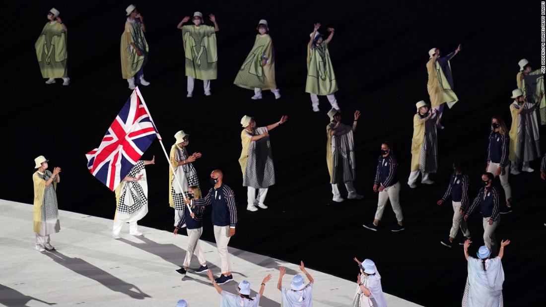 British flag-bearers Hannah Mills and Mohamed Sbihi lead out the team during the opening ceremony&#39;s parade of nations. Sbihi, a rower, made history as Great Britain&#39;s first Muslim flag-bearer.