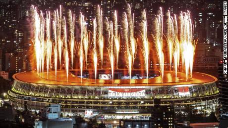 Fogos de artifício iluminam o céu acima do Estádio Olímpico durante a cerimônia de abertura dos Jogos Olímpicos de Tóquio. 