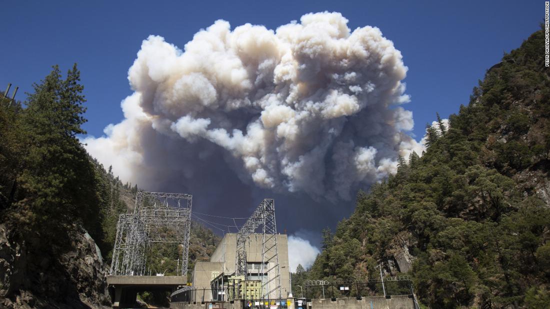 Plumes of smoke from the Dixie Fire rise above California&#39;s Plumas National Forest, near the Pacific Gas and Electric Rock Creek Power House, 在七月 21.