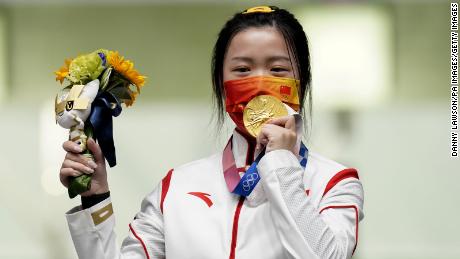 A chinesa Yang Qian comemora medalha de ouro após vencer a final do rifle de ar comprimido feminino de 10m no primeiro dia dos Jogos Olímpicos de Tóquio em 2020.