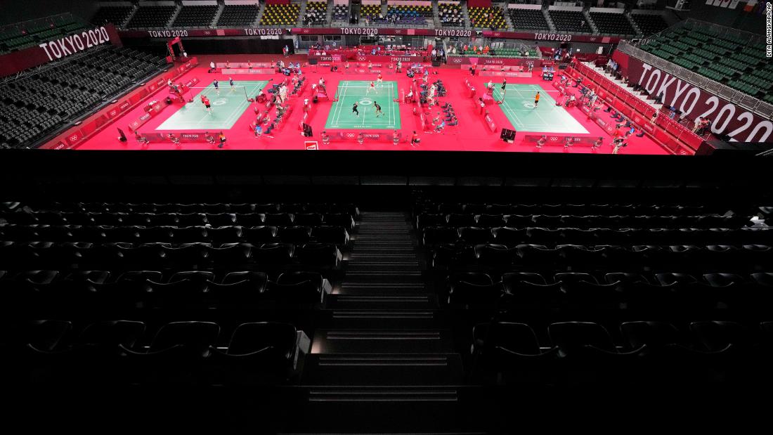 Badminton players compete amid rows of empty seats on July 24.