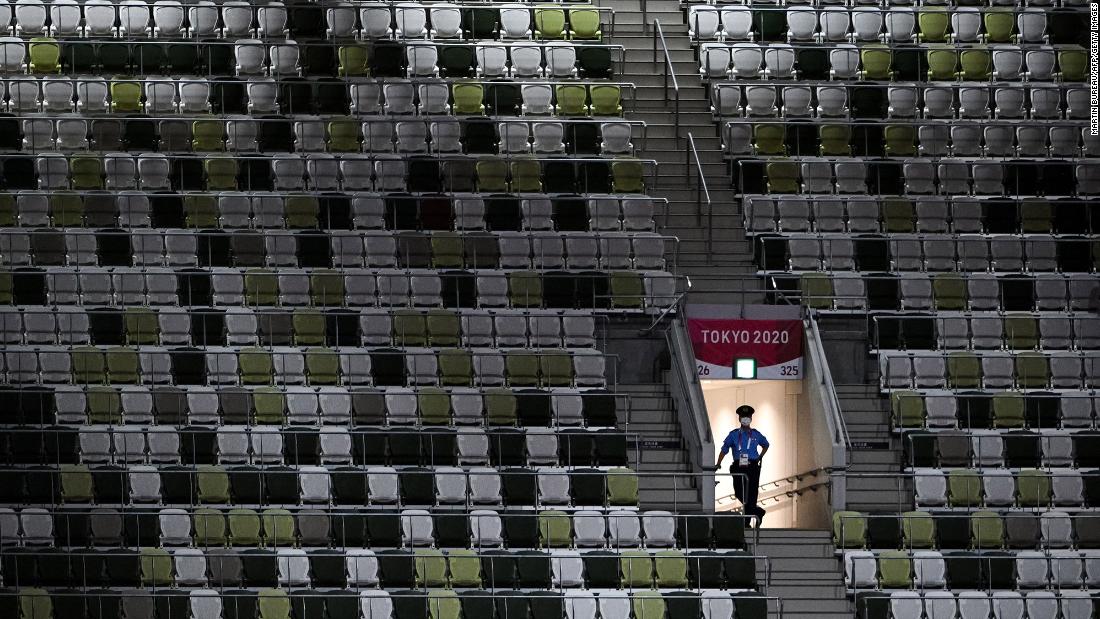A police officer is seen in the mostly empty stadium on July 23. Organizers said that for the opening ceremony, only 950 VIPs would be present in a stadium that can seat nearly 70,000 people.