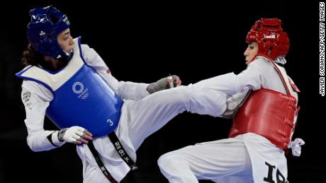 A equipe olímpica refugiada Kimia Alizadeh (azul) e Nahid Kiyani Chandeh do Irã (vermelha) competem na rodada classificatória de taekwondo feminino de até 57 kg nos Jogos Olímpicos de Tóquio 2020 no Makuhari Messe Hall em Tóquio em 25 de julho de 2021.