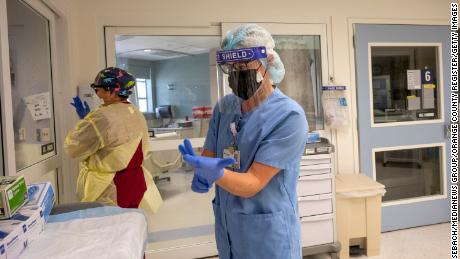 A assistente de enfermagem Vanessa Gutierrez, à esquerda, e Jamie McDonough, RN, entram na sala de pacientes Covid-19 em St.  Joseph Hospital em Orange, Califórnia, na quarta-feira, 21 de julho de 2021. 