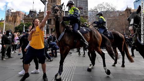 Um manifestante tenta empurrar o cavalo da polícia de Sydney em 24 de julho, enquanto milhares de pessoas protestam contra as ordens de permanência em casa da cidade por um mês.  Não está claro se a pessoa na foto é um dos dois acusados. 