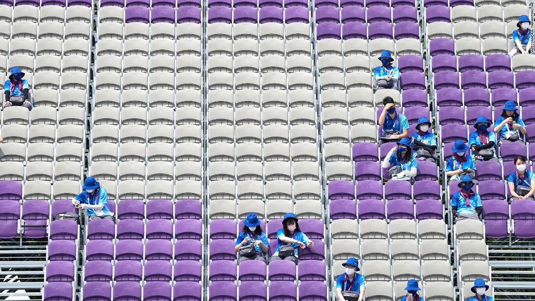 Volunteers sit in mostly empty stands during archery competition on July 26.