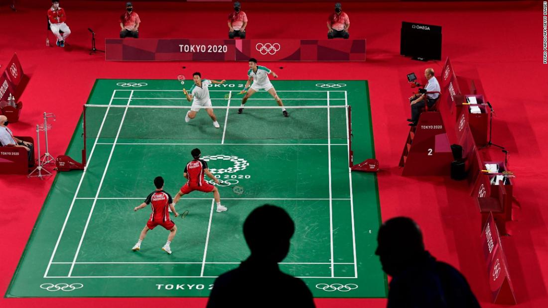 Members of the media are pictured in the foreground as Indonesia&#39;s Marcus Fernaldi Gideon, bottom left, and Kevin Sanjaya Sukamuljo play a badminton match against Taiwan&#39;s Lee Yang, top left, and Wang Chi-lin on July 27.
