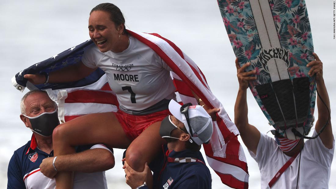 The United States&#39; Carissa Moore celebrates after &lt;a href=&quot;https://www.cnn.com/world/live-news/tokyo-2020-olympics-07-27-21-spt/h_fef4a80c23cb5ec5e96752ab3be966f2&quot; target=&quot;_blank&quot;&gt;she won the first-ever Olympic gold medal in surfing&lt;/a&gt; on July 27.
