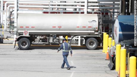 Um trabalhador passa por tanques de gasolina em uma refinaria de petróleo em Utah.