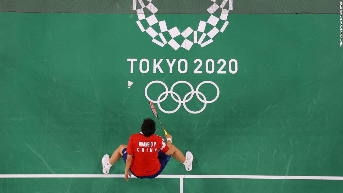 Japanese badminton player Arisa Higashino, top, hits a shot toward China&#39;s Huang Dongping in a mixed-doubles semifinal on July 29.