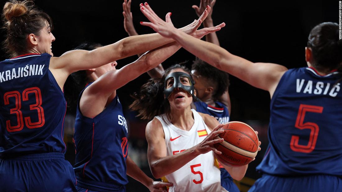Spain&#39;s Cristina Ouviña, center, is defended by a group of Serbian players during a preliminary round basketball game on July 29.
