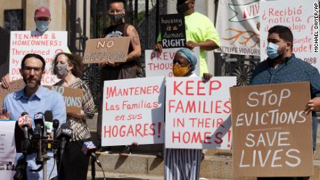 People from a coalition of housing justice groups hold signs protesting evictions during a news conference outside the Statehouse, Friday, July 30, 2021, in Boston. 