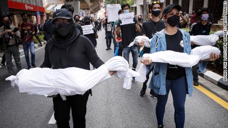 Protesters hold fake corpses during a demonstration near Independence Square in Kuala Lumpur, demanding the resignation of the prime minister over his handling of the coronavirus pandemic.