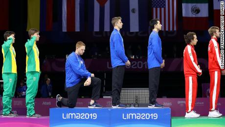 Race Imboden (third from left) takes the knee during the National Anthem Ceremony in the podium of men&#39;s foil team gold medal match at the 2019 Pan American Games in Lima, Peru. 