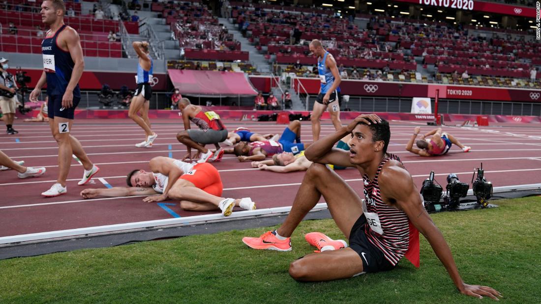 Decathletes rest on the track following the 1,500 meters on August 5.