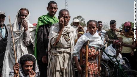 People wait to receive food aid from a local NGO in Tigray&#39;s capital Mekele in June.