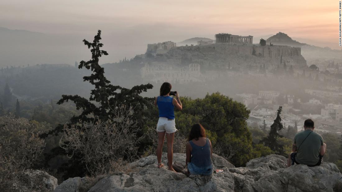 Onlookers view the smoke from the wildfires blanketing Athens&#39; Acropolis on August 4.
