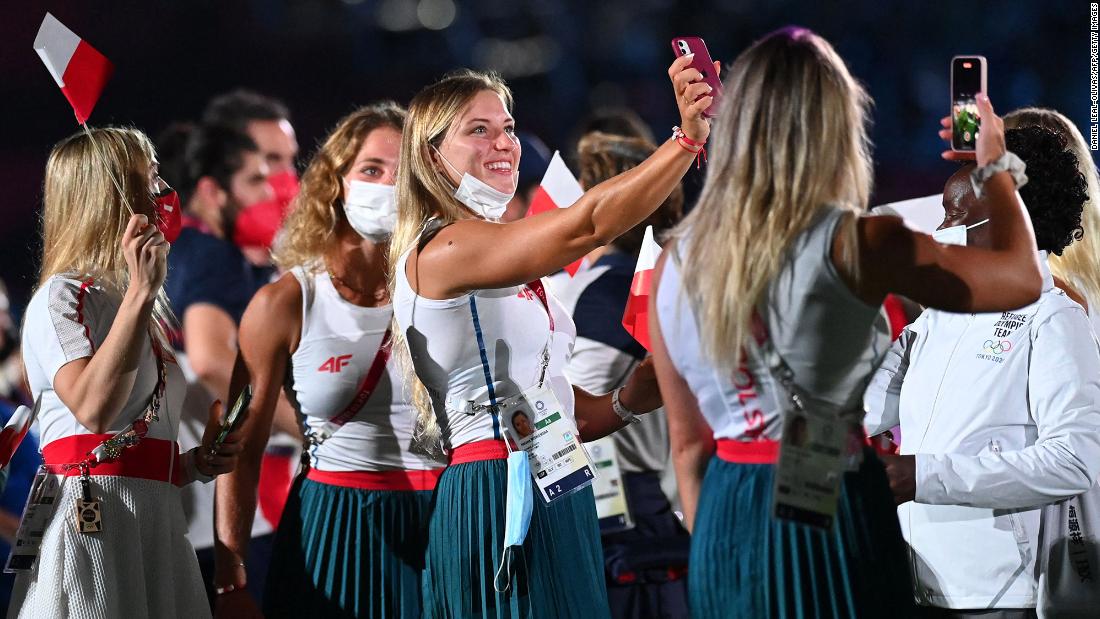 Polish athletes take pictures as they attend the closing ceremony.