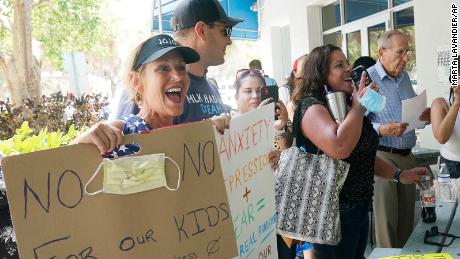 Joann Marcus, à esquerda, comemora enquanto ouve a reunião extraordinária do Conselho Escolar de Broward na quarta-feira, 28 de julho em Fort Lauderdale, Flórida.