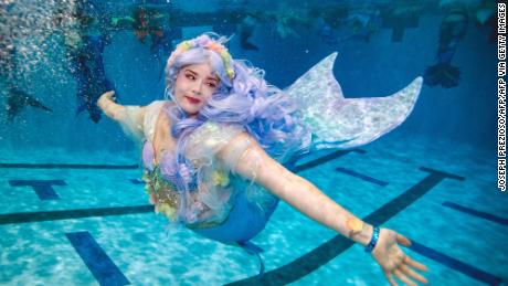 A mermaids swims during MerMagic Con at the Freedom Aquatic Center in Manassas, Virginia on August 7, 2021. - MerMagic Con is advertised as the largest Mermaid convention in the world. Some parts of the convention are based on modeling and looks like the Miss Mermaid USA Pageant. The Society of Fat Mermaids looks to bring together plus size people and promote the idea that anyone can become a mermaid. Becoming a mermaid is not cheap, most merfolk spend thousands of dollars on their tail and outfit. Most tails are custom made out of silicone and others are foam and fabric. (Photo by Joseph Prezioso / AFP) (Photo by JOSEPH PREZIOSO/AFP via Getty Images)