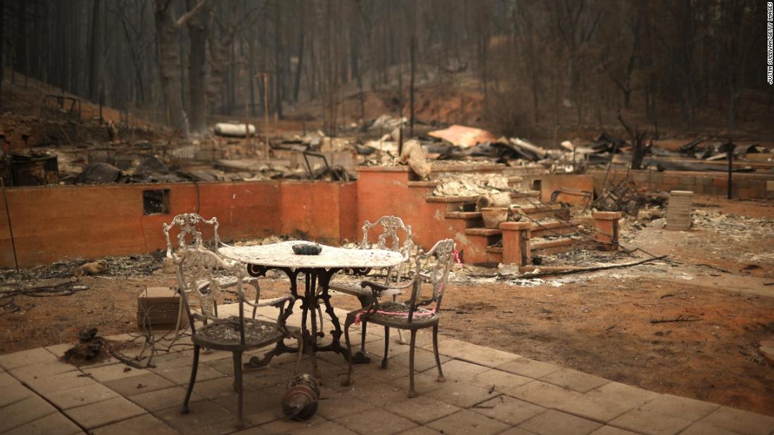 A table and chairs sit in front of a destroyed home in Greenville, Kalifornië, op Augustus 12.