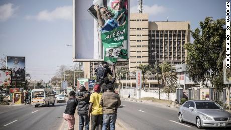 Supporters of Zambian President elect for the opposition party United Party for National Development (UPND) Hakainde Hichilema remove a poster of the former president Edgar Lungu from a pole in Lusaka, on August 16, 2021. 