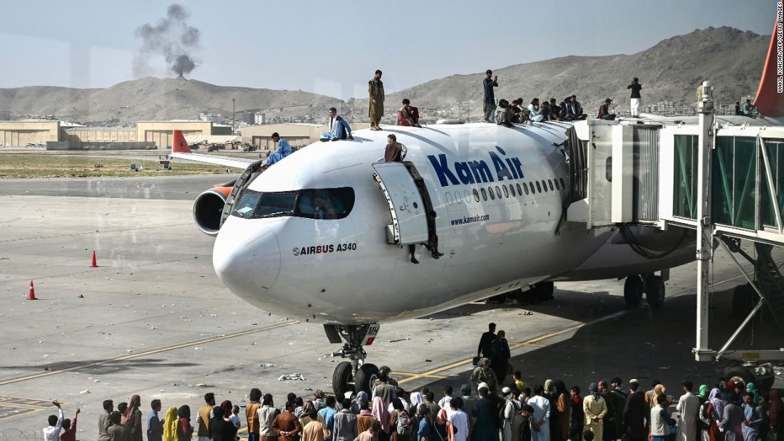 People climb atop a plane at the airport in Kabul on August 16. 수백명의 사람들&lt;a href =&quot;https://www.cnn.com/2021/08/16/middleeast/kabul-afghanistan-withdrawal-taliban-intl/index.html&quot; target =&quot;_공백&am인용ot;&gt; were on the tarmac, trying to find a way out of the country.ltmp;lt;/ㅏ&amgtgt;