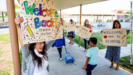 Third-grade teacher Candace Ropp, left, welcomes students back for the first day of class Monday at Stanford Elementary School in Garden Grove, California.